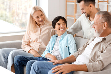 Little boy with his family sitting on sofa at home