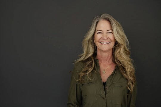 portrait of beautiful smiling woman in her fifties with long blonde hair wearing an olive green shirt dress