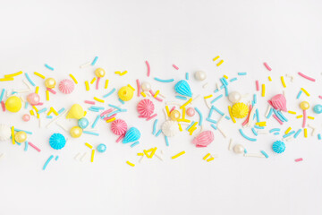 Fototapeta na wymiar Sweet colorful sprinkles scattered on white background