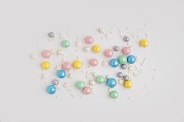 Sweet colorful sprinkles scattered on white background