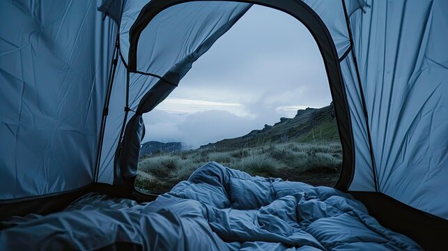 beautiful view of the mountains from outside the tent. The opening of the tent acts as a natural frame for the landscape, drawing the viewer to the majestic mountains.