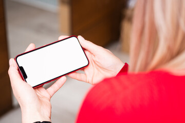 A woman uses a modern smartphone. Mockup of a phone screen held in women's hands