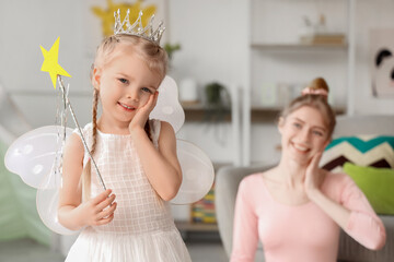 Cute little girl dressed as fairy with her mother at home