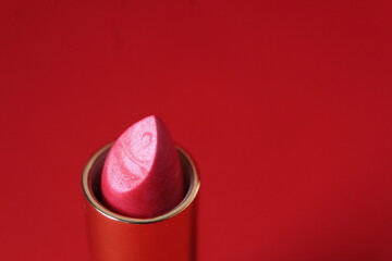Pink lipstick on red background with space for copy space text