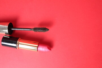 Selection of makeup tools on a red background with space for copyspace text