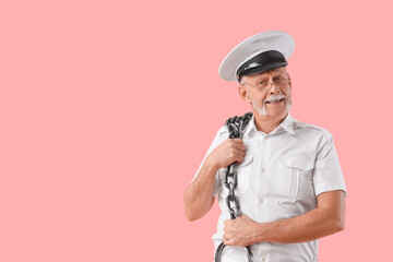Mature sailor with chain on pink background