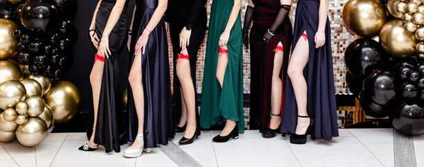 Young girls showing off their legs with red garters during the high school prom, also called 