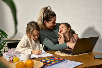 In the midst of homework, the younger daughter joins in for some cuddles, turning the study table...