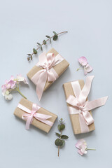 Festive wrapped gift boxes with flowers on blue background