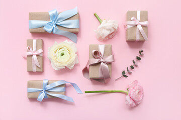 Festive wrapped gift boxes with roses on pink background