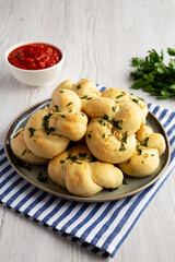 Homemade Garlic Knots with Parsley on a Plate, side view.