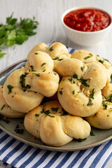 Homemade Garlic Knots with Parsley on a Plate, side view.