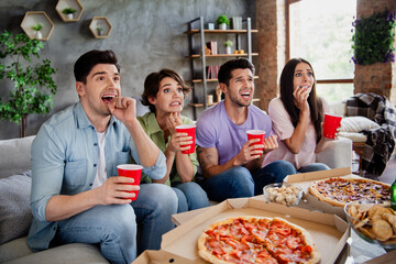 Photo of group nervous impressed people sitting couch hold plastic drink cups watch scary movie...