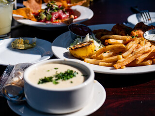 Image of an outdoor restaurant lunch with fish and chips, poke, and clam chowder