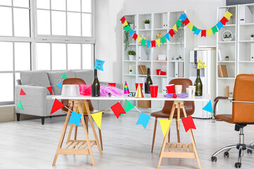 Table with champagne and party decor in office. April Fools' Day celebration