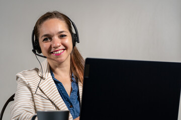 Mujer asistente en una tele llamada, sonriente y mirando a cámara. Concepto de mesa de ayuda y...