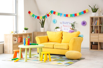 Interior of living room decorated for April Fools' Day with sofa and juggling clubs on table