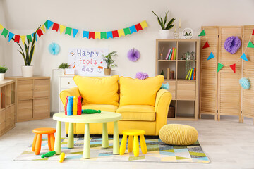 Interior of living room decorated for April Fools' Day with sofa and juggling clubs on table