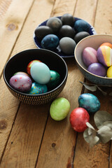 colored Easter eggs in a bowl an a wooden table
