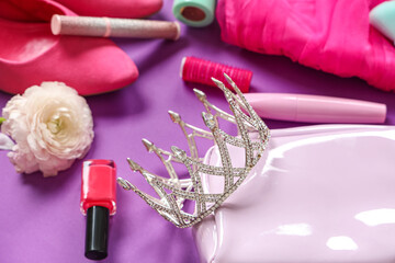 Obraz na płótnie Canvas Cosmetic bag with female prom crown on purple background, closeup
