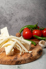 String cheese. Grains of string cheese on a wood serving board