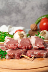 Lamb sirloin. Lamb sirloin meat skewered on a wooden serving board. Close up