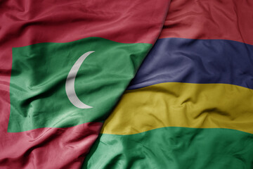 big waving national colorful flag of mauritius and national flag of maldives .