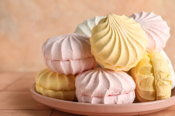 Plate of sweet zefirs on beige background