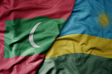 big waving national colorful flag of rwanda and national flag of maldives .