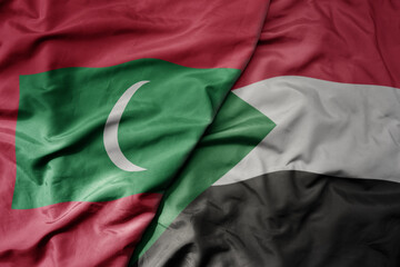 big waving national colorful flag of sudan and national flag of maldives .