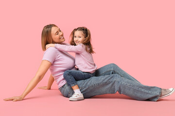 Obraz na płótnie Canvas Little girl and her mother spending time together on pink background. Mother's Day