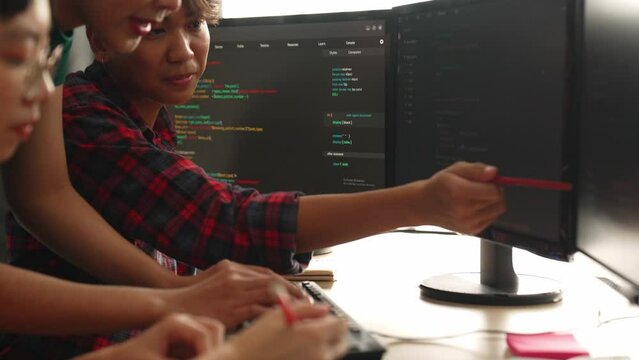 Slow motion back end software developer engineer for computer programming working together on debugging writing computing code, solving complex algorithms display on monitor in office. Burgeoning