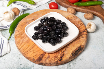 Black olive. Delicious olives grown in the Mediterranean region on a wooden serving board
