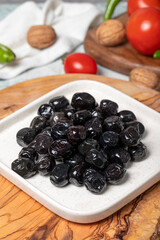 Black olive. Delicious olives grown in the Mediterranean region on a wooden serving board