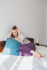 Young woman suffering from panic attack sitting on the bed - 763597044