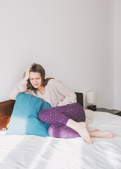 Woman suffering from panic attack sitting on the bed at home