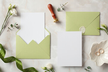 Top view photo of wedding stationery set on stone background. Flat lay olive color envelopes, blank...
