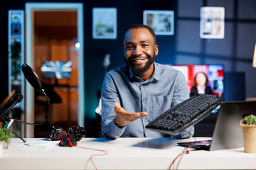 Influencer in home studio using recording tech to capture live broadcast, reviewing mechanical...