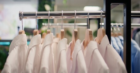 Close up shot of high quality garments in premium clothing store. Elegant formalwear white shirts...