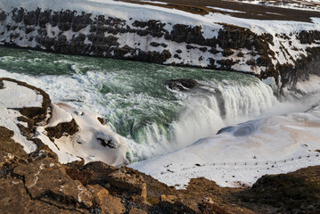 River Hvítá plunging down the lower stage of the mighty Gullfoss waterfall into a crevice, winter...