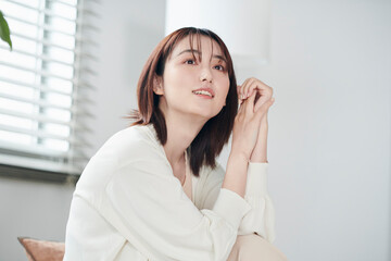 Obraz premium ベッドに腰掛ける20代女性