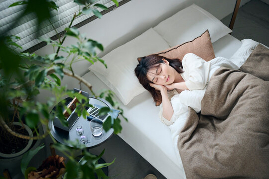 ベッドで眠る20代女性