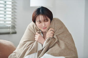 目が覚めて体を伸ばす20代女性,朝