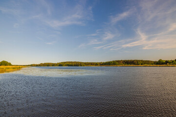 Beautiful view of serene azure expanse of the lake seamlessly merges with the boundless blue sky on...