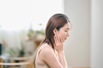 Naklejka premium 鏡の前でスキンケアをする20代女性