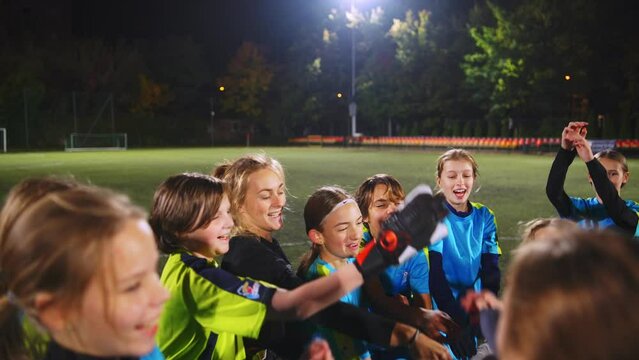 teenage soccer player girls standing on a circle with their coach and jumping. High quality 4k footage