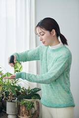 観葉植物の世話をする20代女性