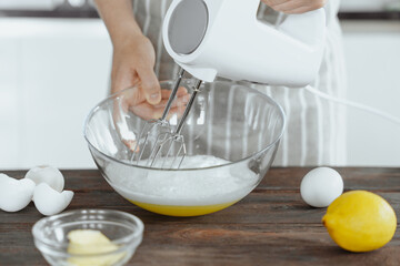 Close-up of Hand Whisking Eggs with Electric Mixer