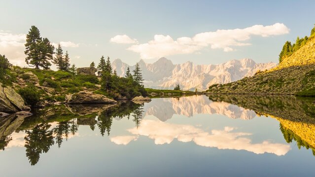 The Hoher Dachstein is reflected in the lake of mirrors at last daylight, Reiteralm, Styria, Austria, Europe