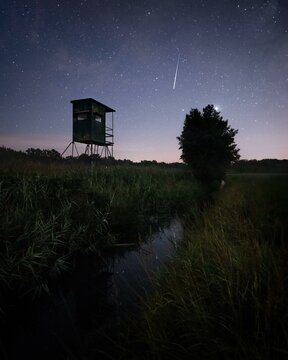 Perseids shooting star over field with hunter's seat, Brandenburg, Germany, Europe